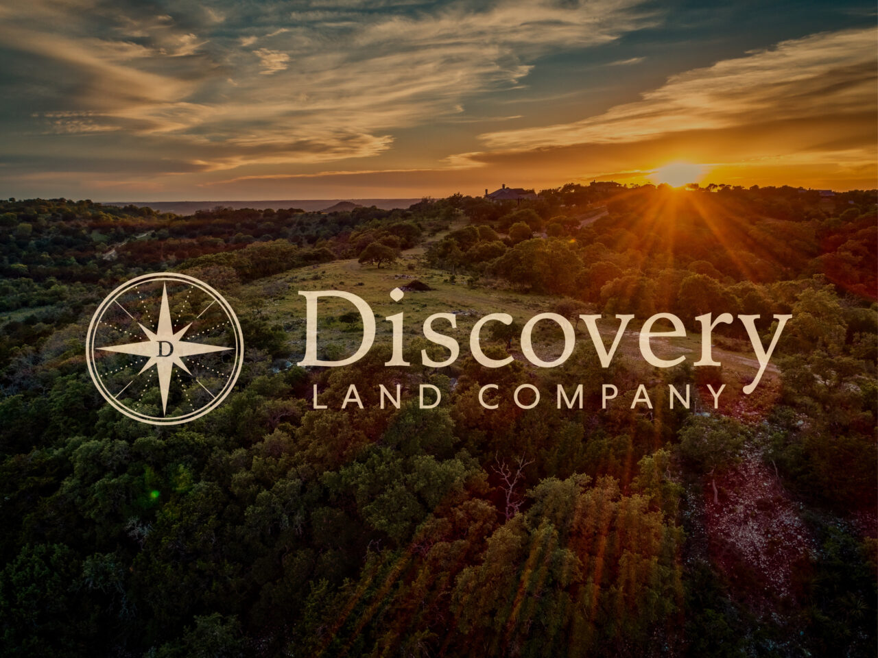 A landscape with rolling hills and trees at sunset features the Discovery Land Company logo and text overlay.