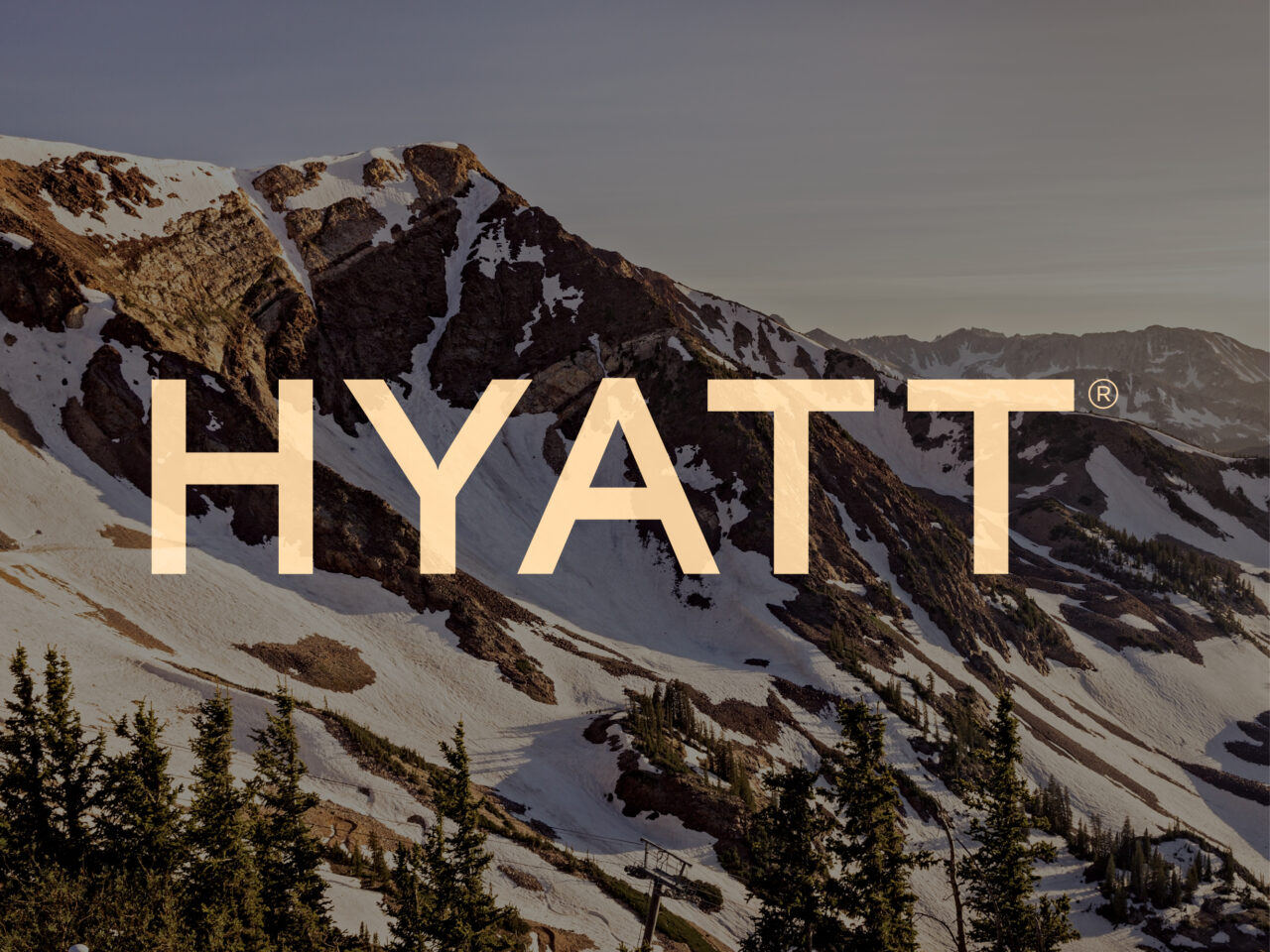 Snow-capped mountains and pine trees with the large word "HYATT" in bold, tan letters overlaid across the center of the image.