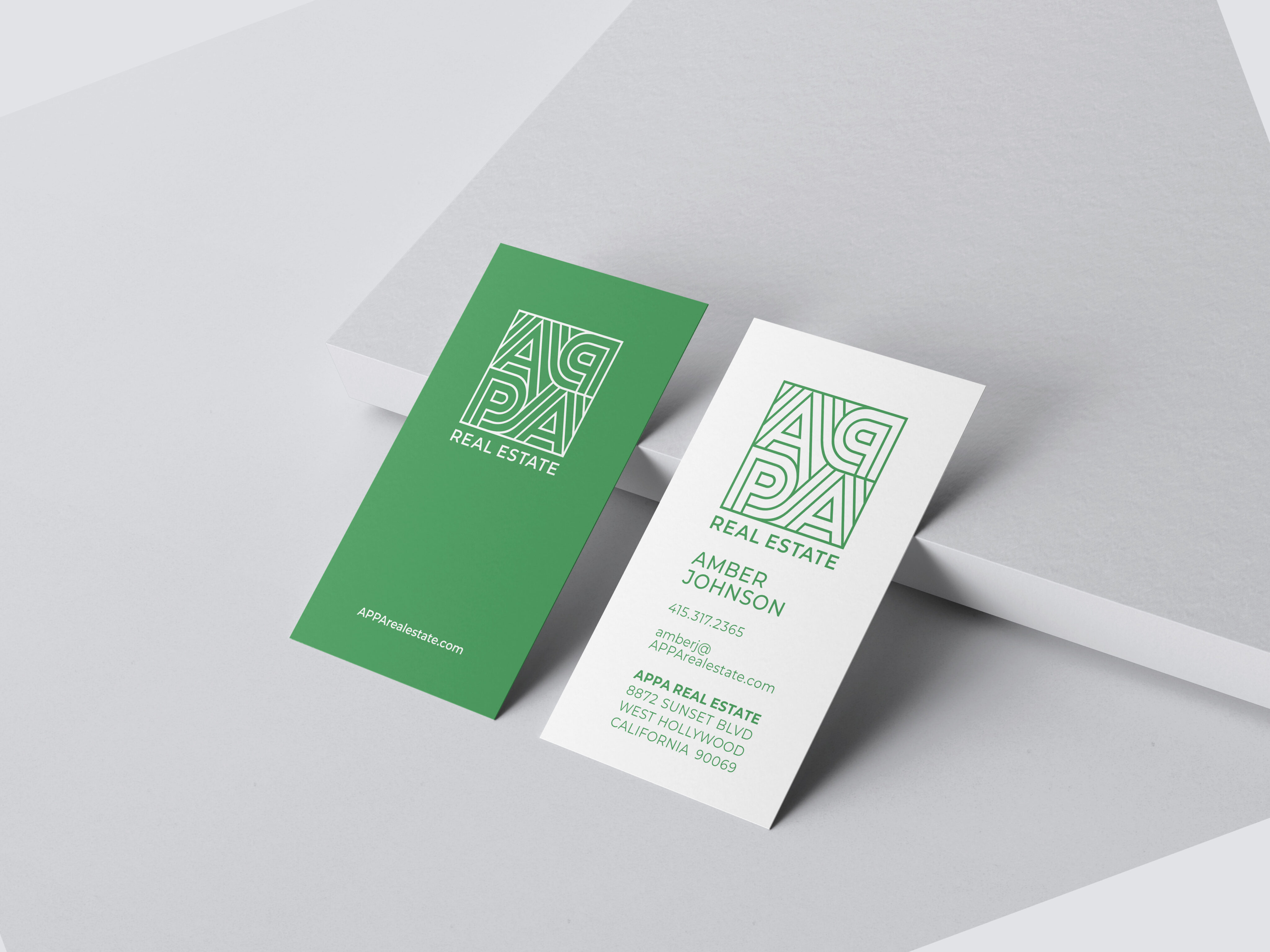 Two business cards for ARPA Real Estate, one green and one white, display the company logo, name, contact details, and the name Amber Johnson on a light gray background.