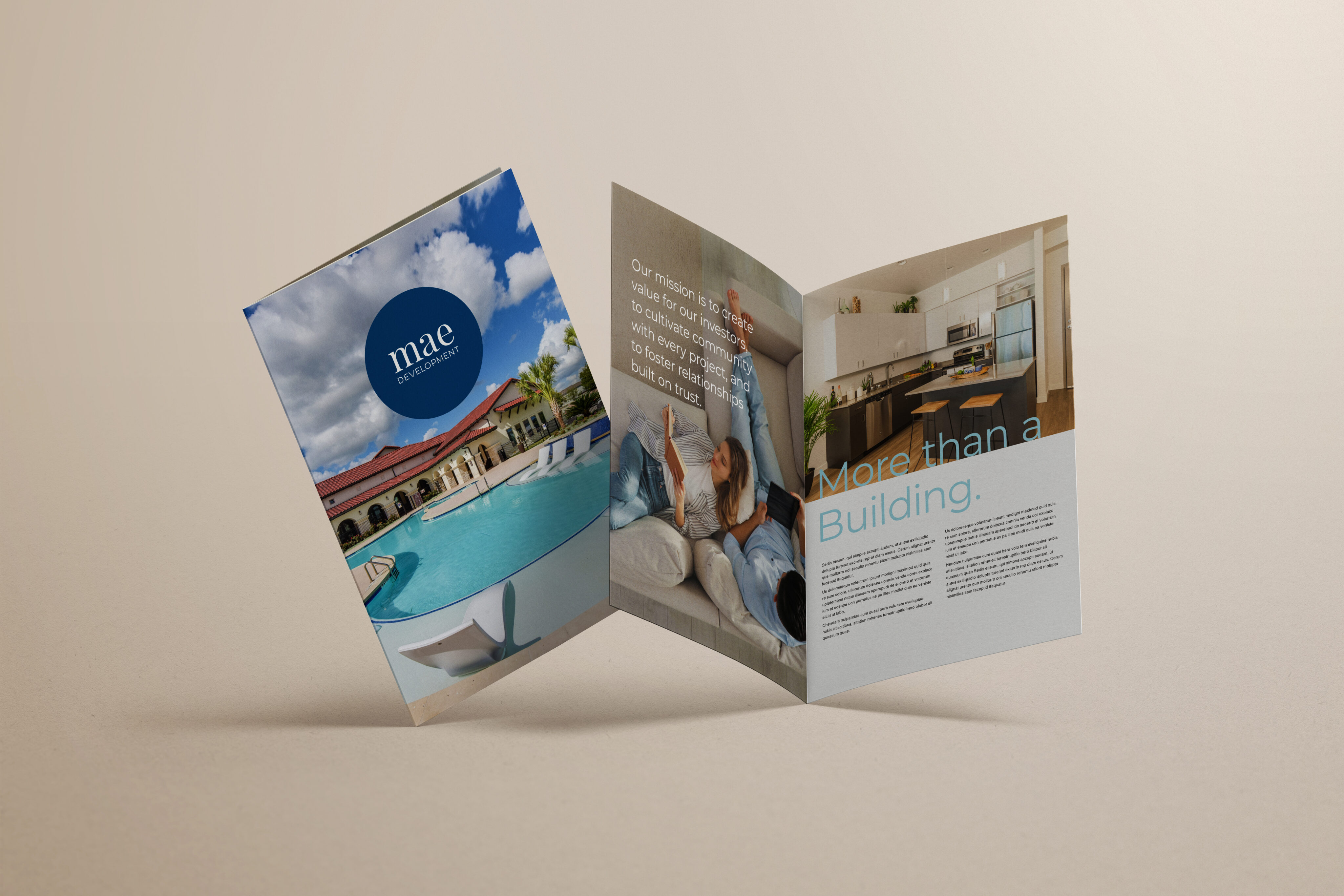 A three-panel brochure stands open, displaying images of a pool, a woman sitting on a sofa, and a modern kitchen, with text describing residential amenities.