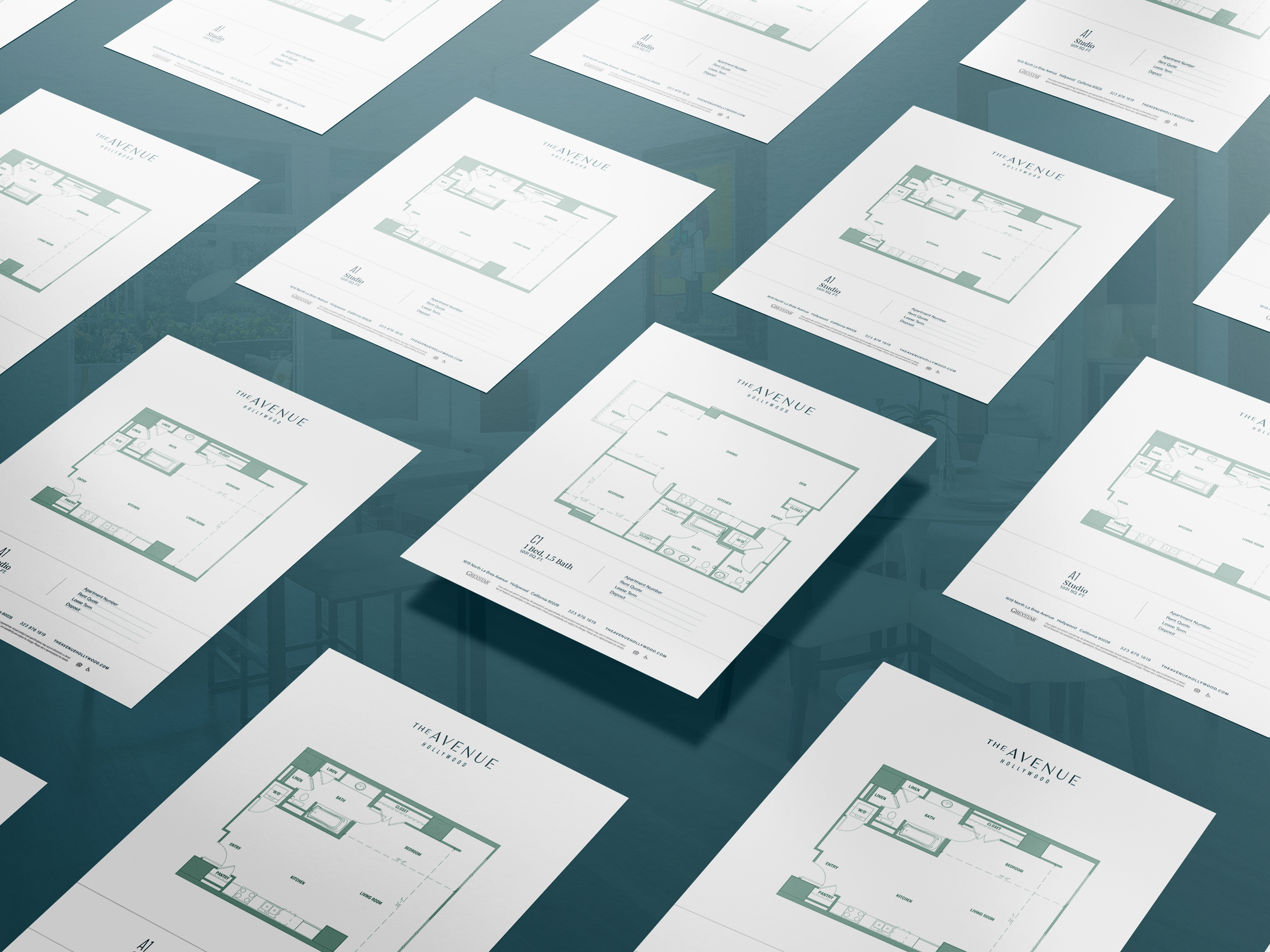Multiple printed floor plans are arranged in a diagonal grid pattern on a reflective surface, each labeled "The Avenue" with layout details visible.