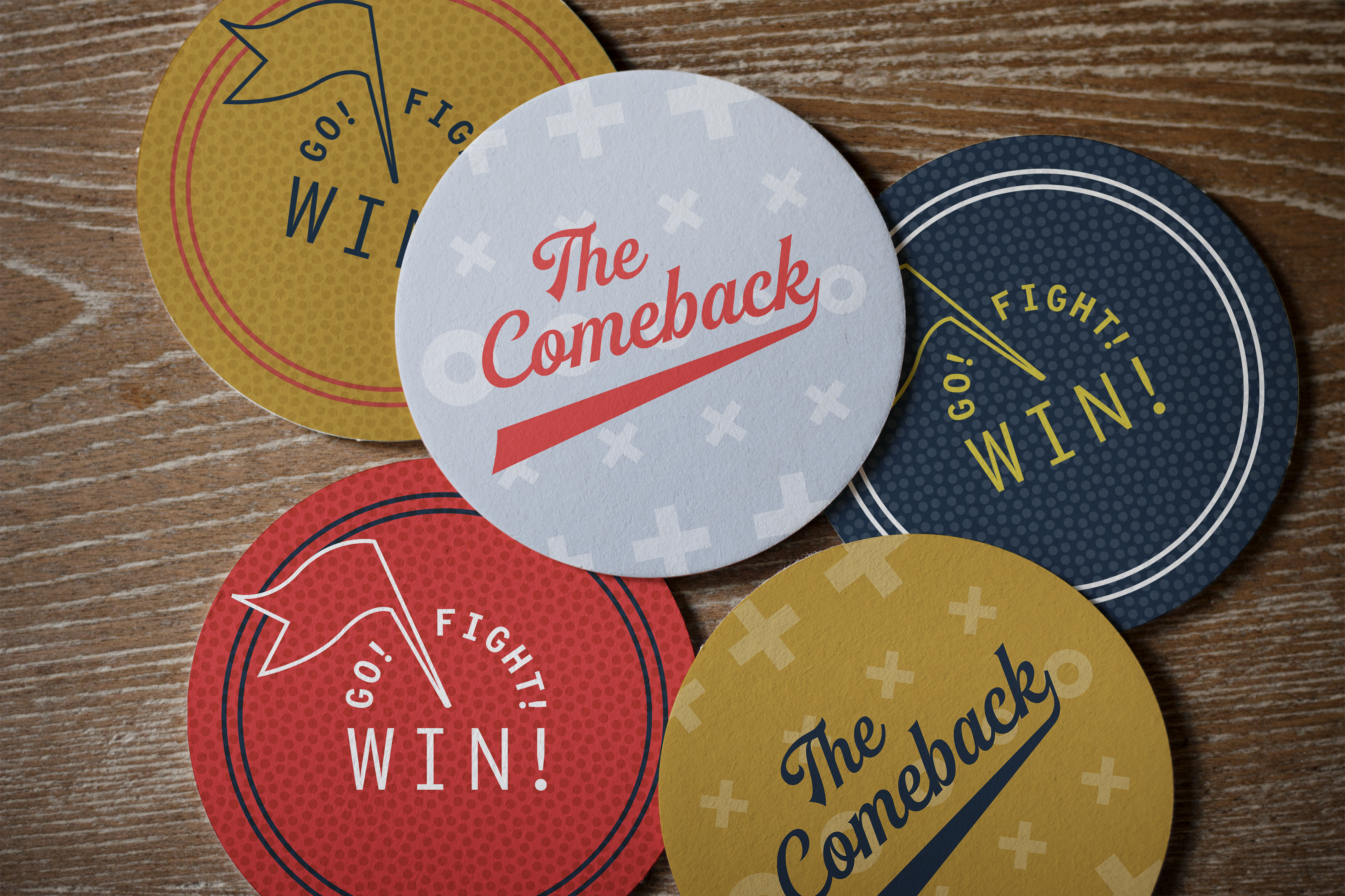 Five round coasters with motivational phrases such as "The Comeback" and "Go! Fight! Win!" are arranged on a wooden surface.