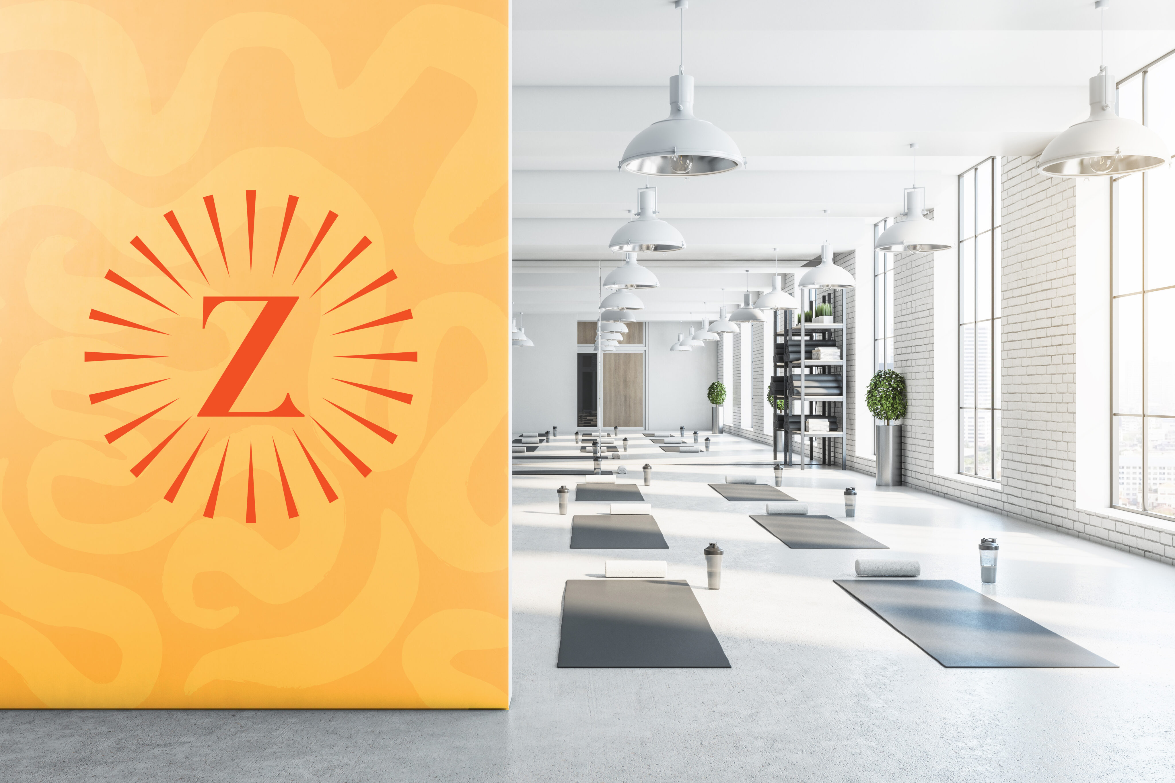 A modern yoga studio with mats, water bottles, and towels arranged on the floor; a large yellow wall with a red "Z" logo is visible on the left.