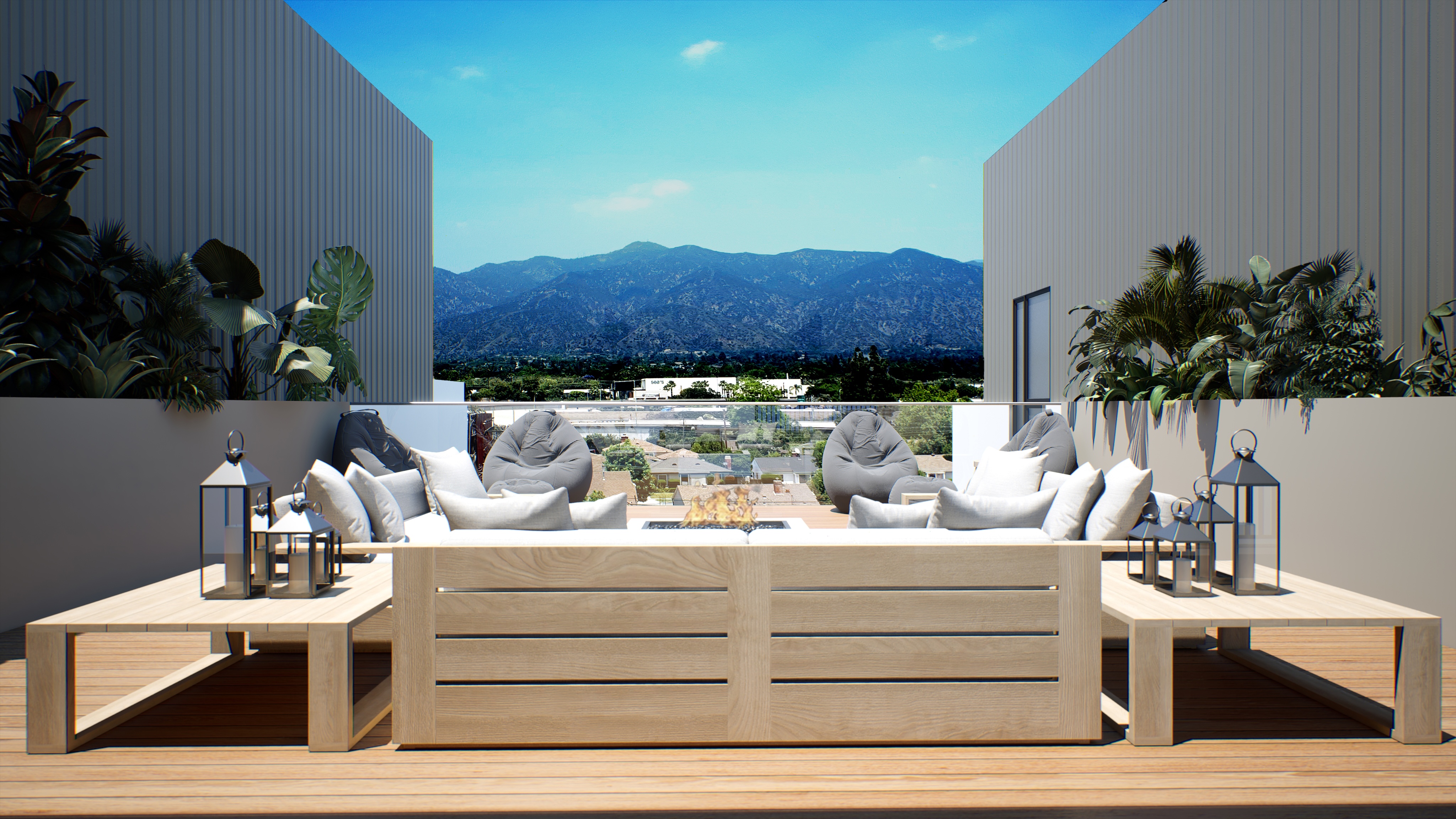 A modern outdoor patio with light wood furniture, gray cushions, lanterns, and potted plants, overlooking a cityscape and distant mountains under a clear blue sky.