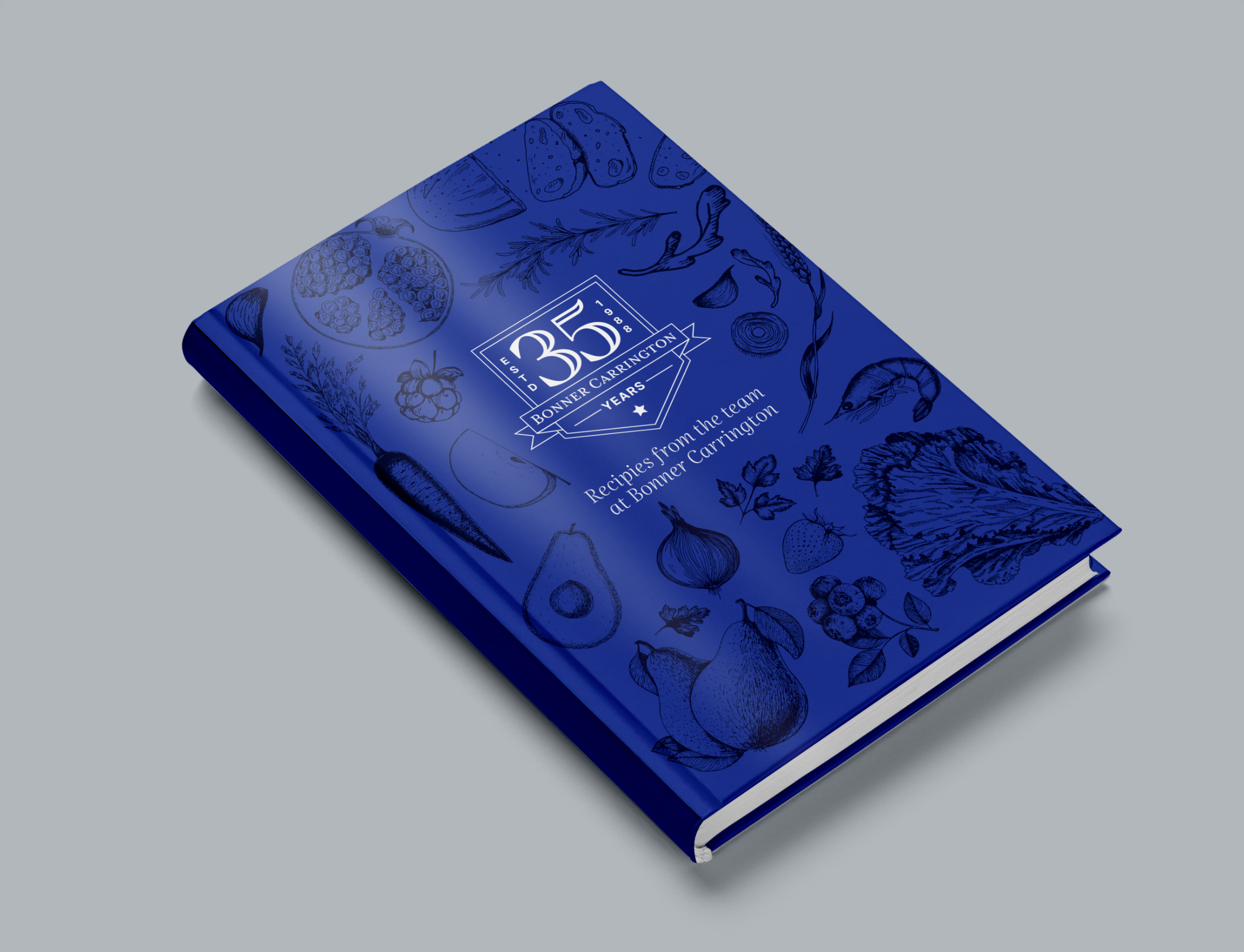 A blue hardcover book titled "35 Years: Recipes from the team at Banner Corporation" with illustrations of various foods on the cover.