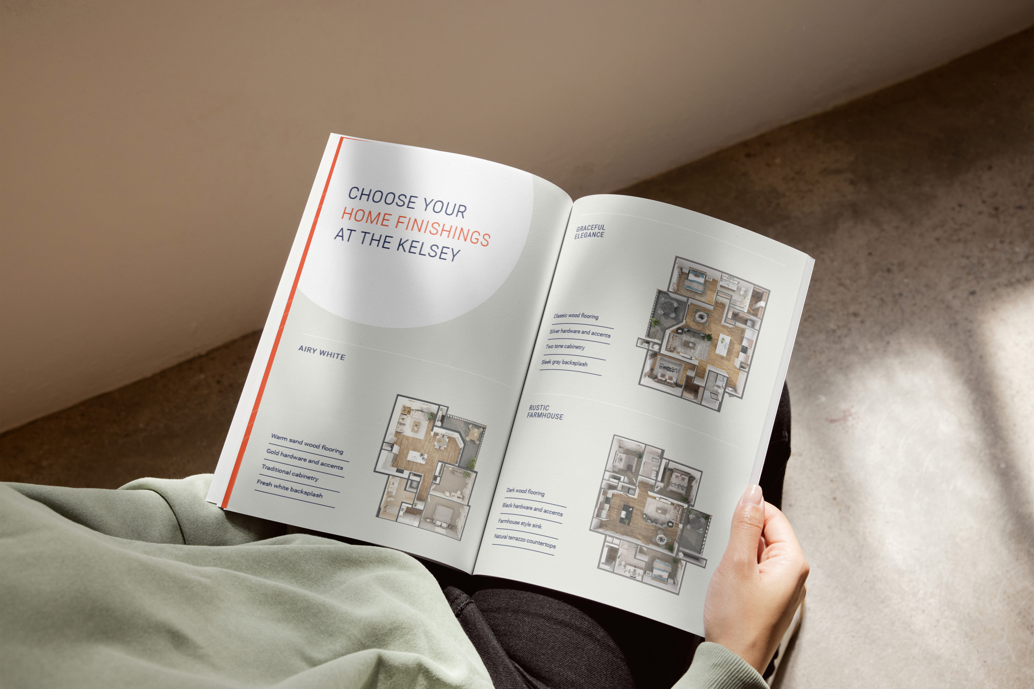 Person holding open a brochure displaying floor plans and text about choosing home finishings at a place called The Kelsey.