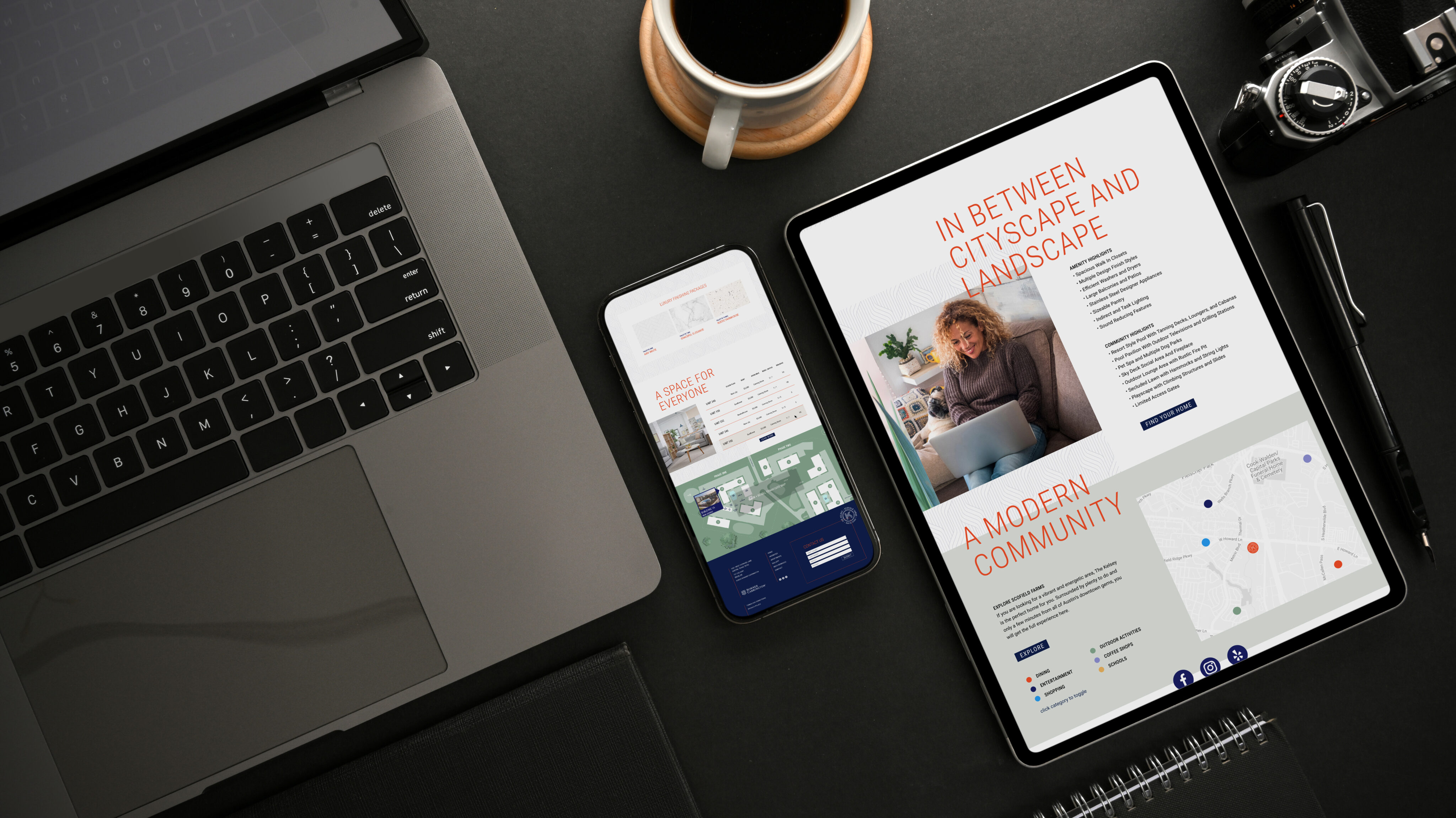 A laptop, smartphone, tablet displaying a website, a camera, and a cup of coffee are arranged on a dark desk.