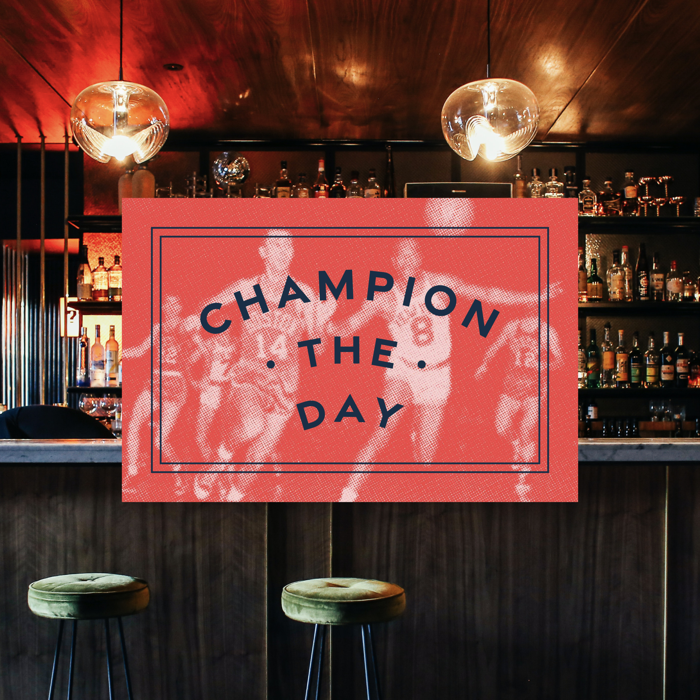 A bar interior with two stools and a counter, featuring a large red sign displaying "CHAMPION THE DAY" over a faded image of athletes.