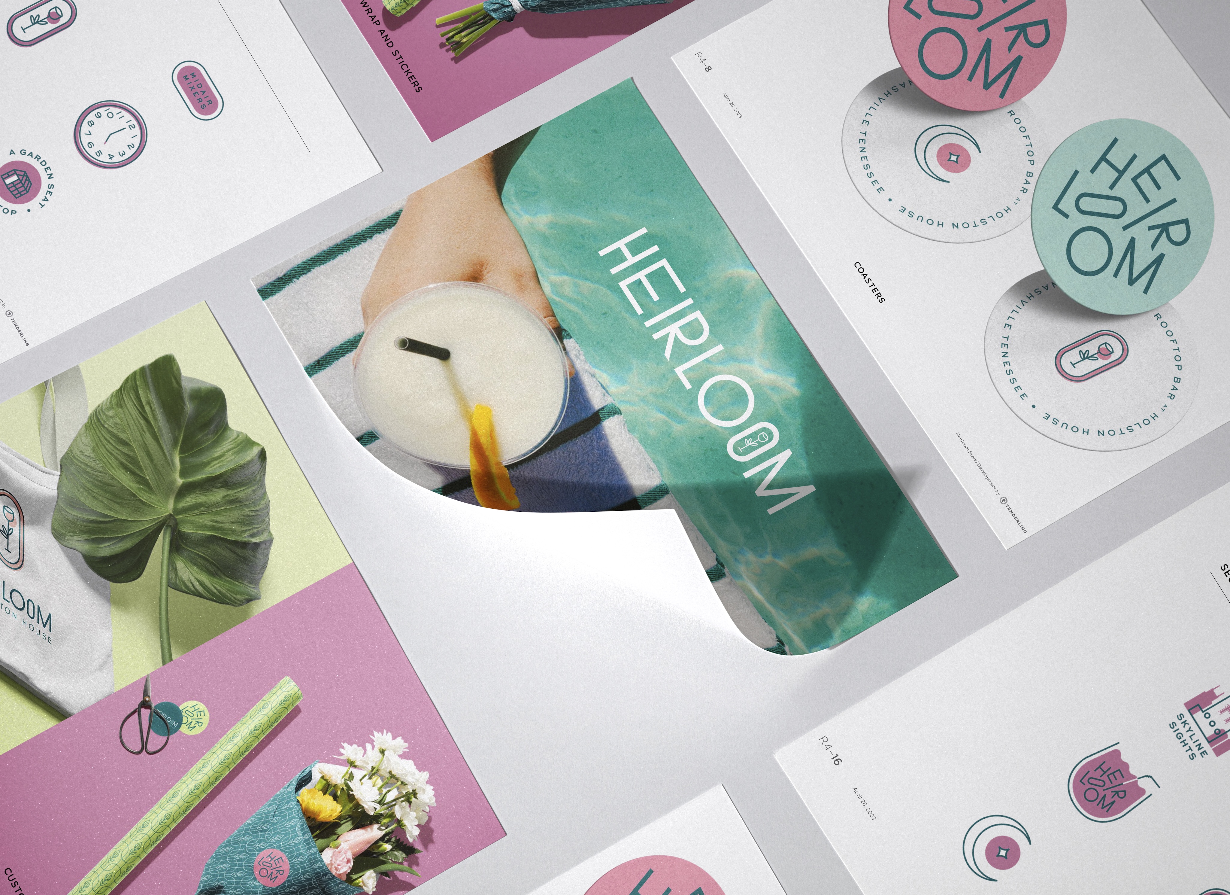 Assorted HEIRLOOM branded marketing materials are spread out, featuring pastel colors, round logos, botanical images, and a drink with a straw.
