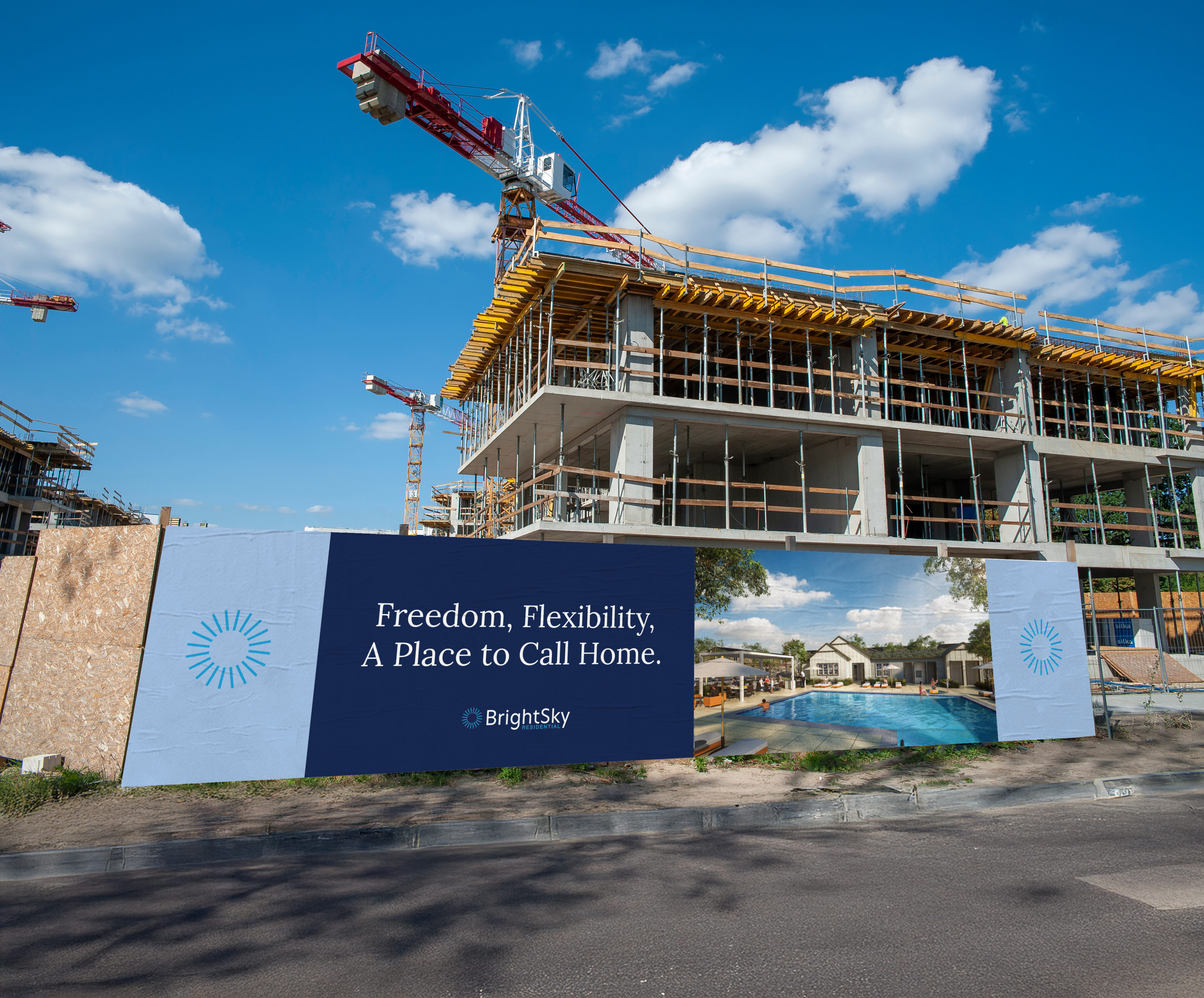 A multi-story building under construction with a billboard advertising housing, featuring the text: "Freedom, Flexibility, A Place to Call Home.
