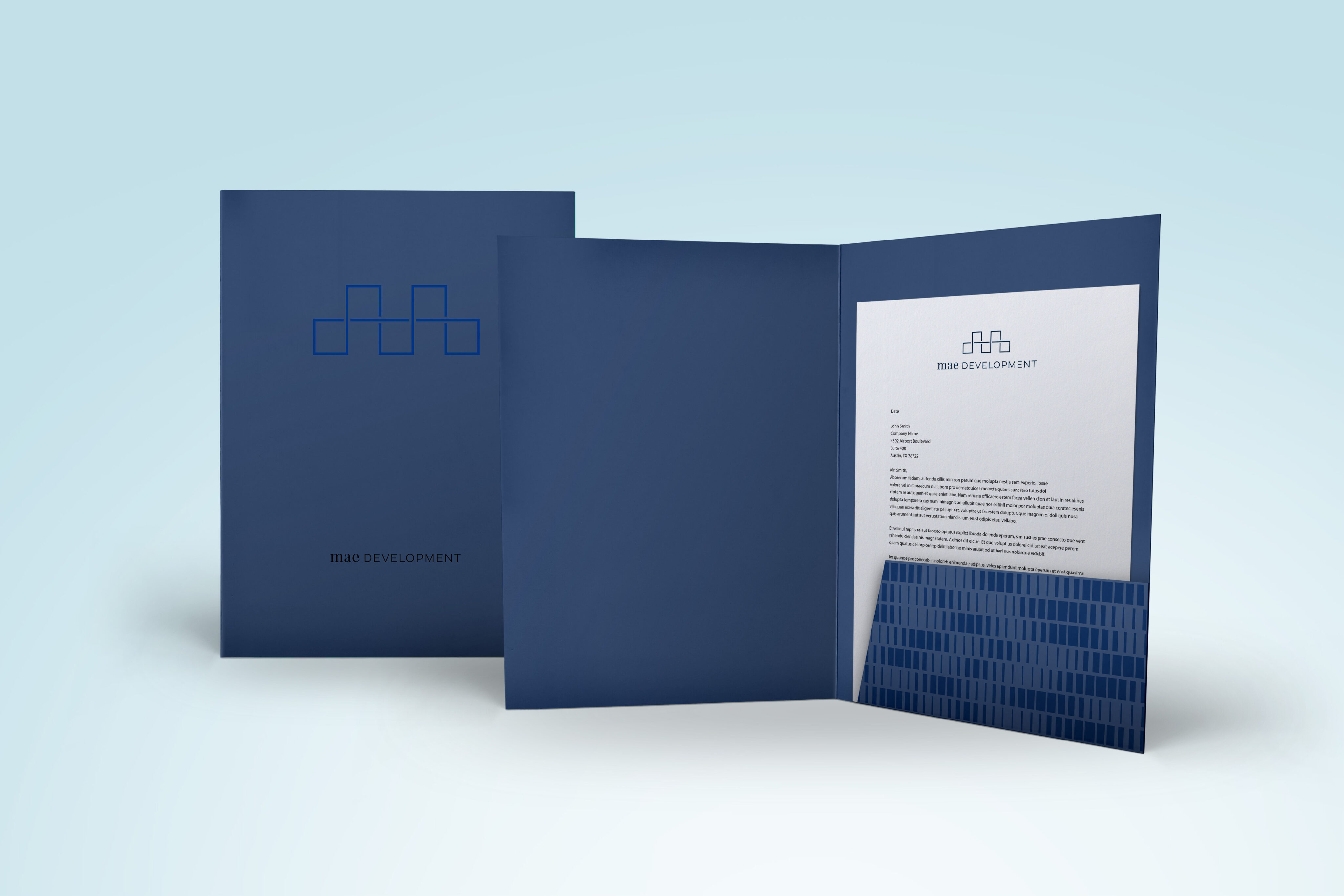 A blue presentation folder with a geometric logo and “DEVELOPMENT” text holds a letter inside; a similar folder is closed and placed beside it on a plain background.