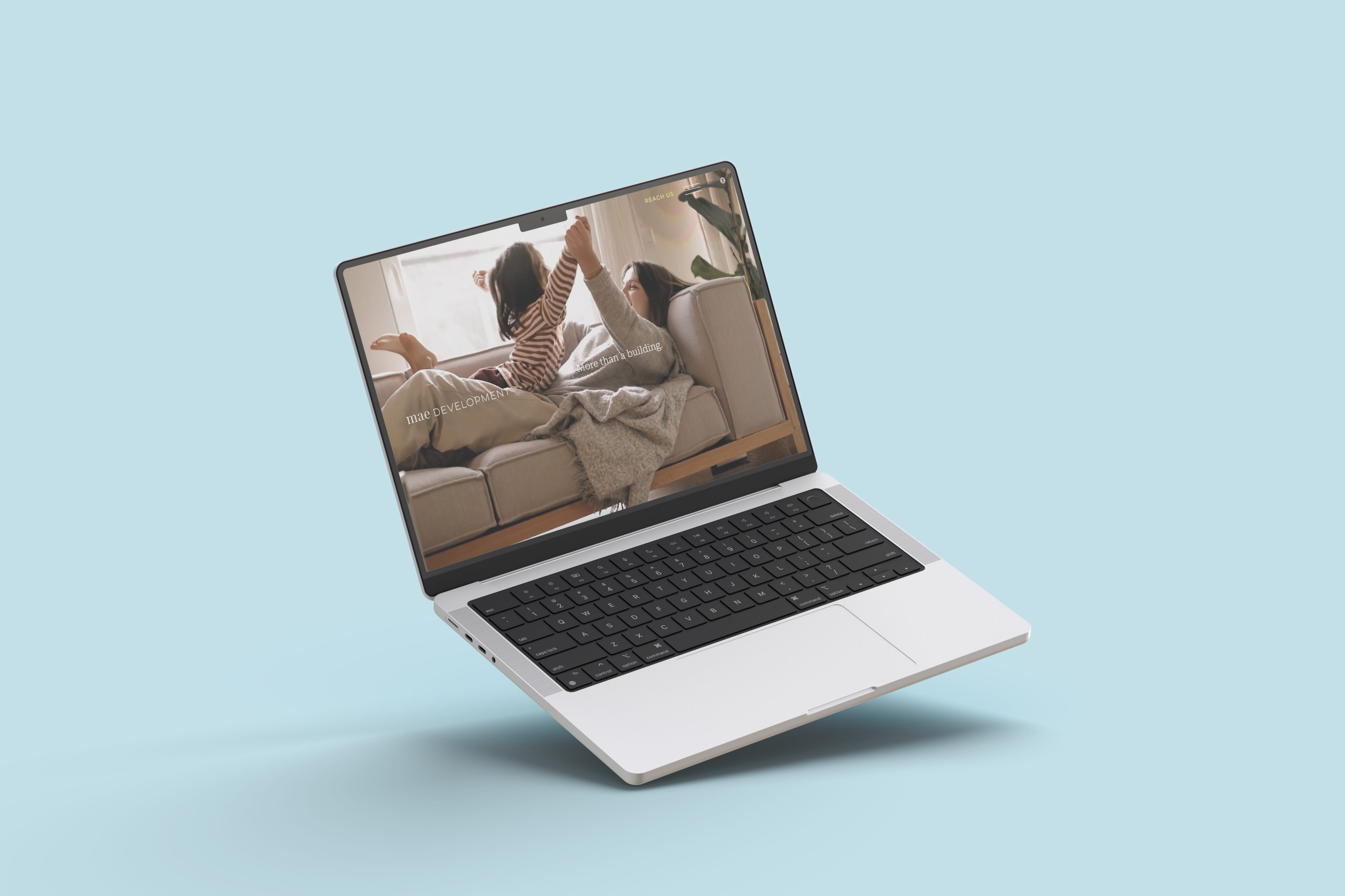 A white laptop floats against a light blue background, displaying an image of two people relaxing on a couch.
