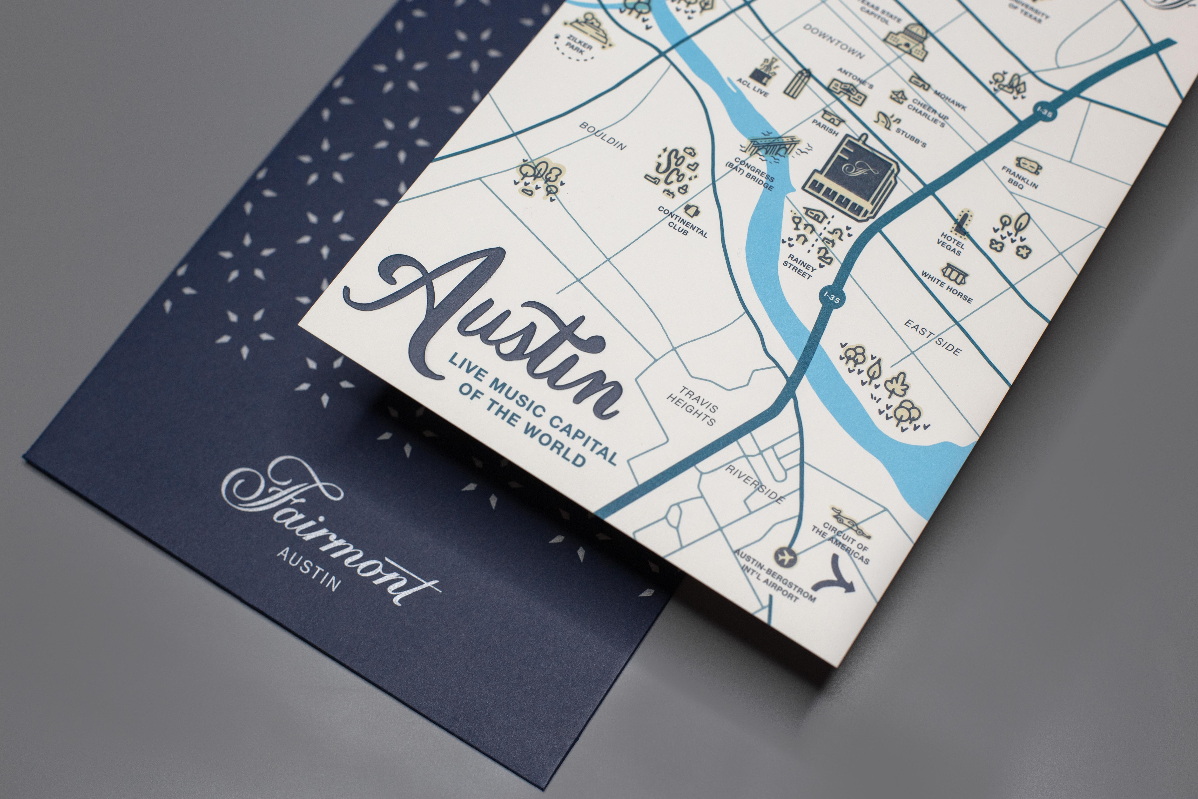 A folded illustrated map of Austin, labeled "Live Music Capital of the World," rests on a navy Fairmont Austin folder.