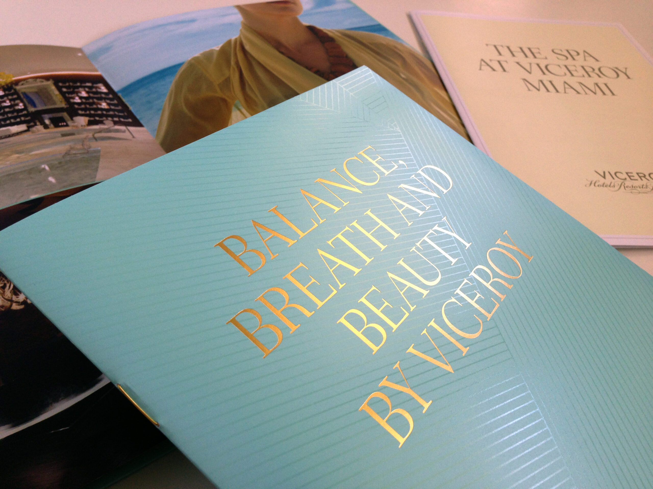 A close-up of three Viceroy Miami brochures, with one prominently displaying the text "Balance, Breath and Beauty by Viceroy" in gold letters on a teal cover.