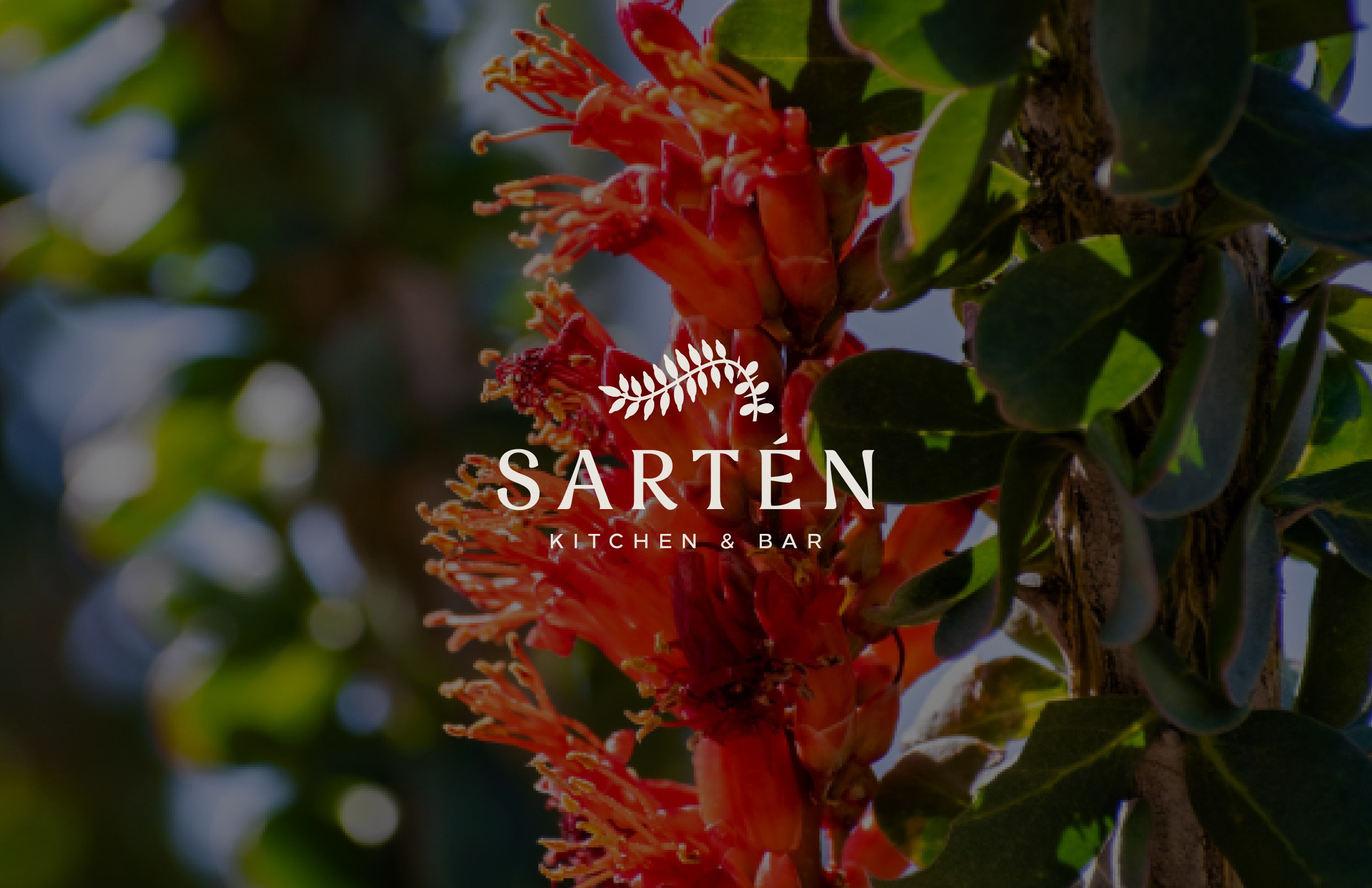 Close-up of a red tropical flower next to green leaves, with the "Sartén Kitchen & Bar" logo and leaf graphic overlay at the center.